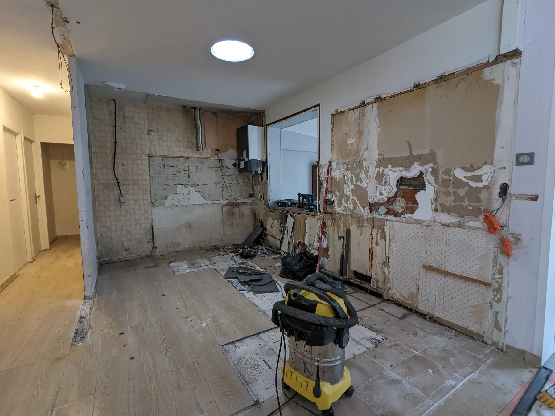 Cuisine déposée pendant les travaux avec murs et réseaux apparents