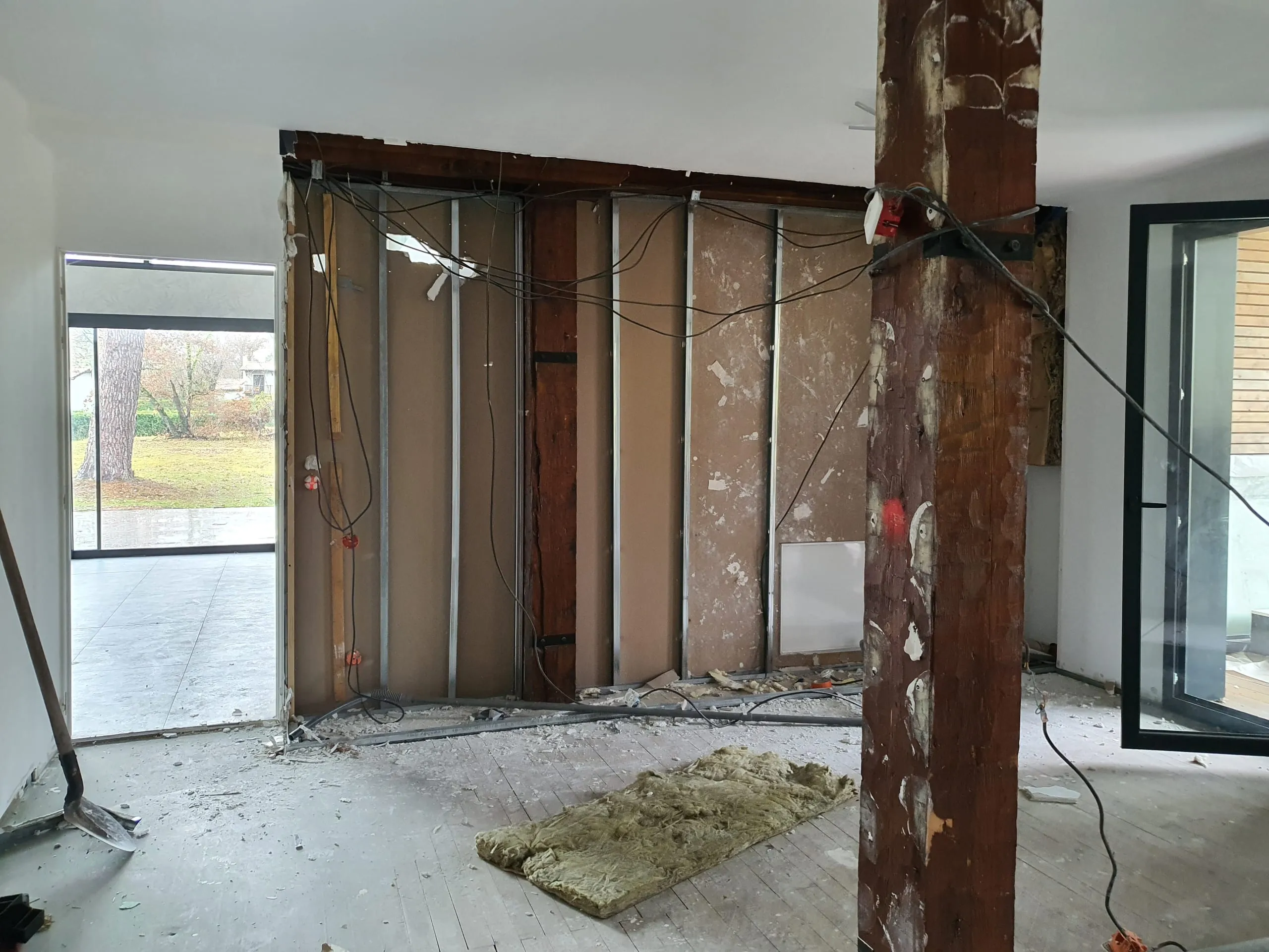 Cloison ouverte, montants et réseaux apparents pendant la rénovation de la maison du projet Lyre
